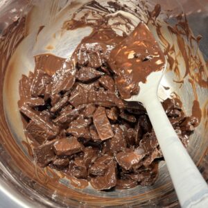 semi melted Lindt Excellence 70% cacao dark chocolate on a double-boiler to prepare sab pastries dark chocolate whipped ganache